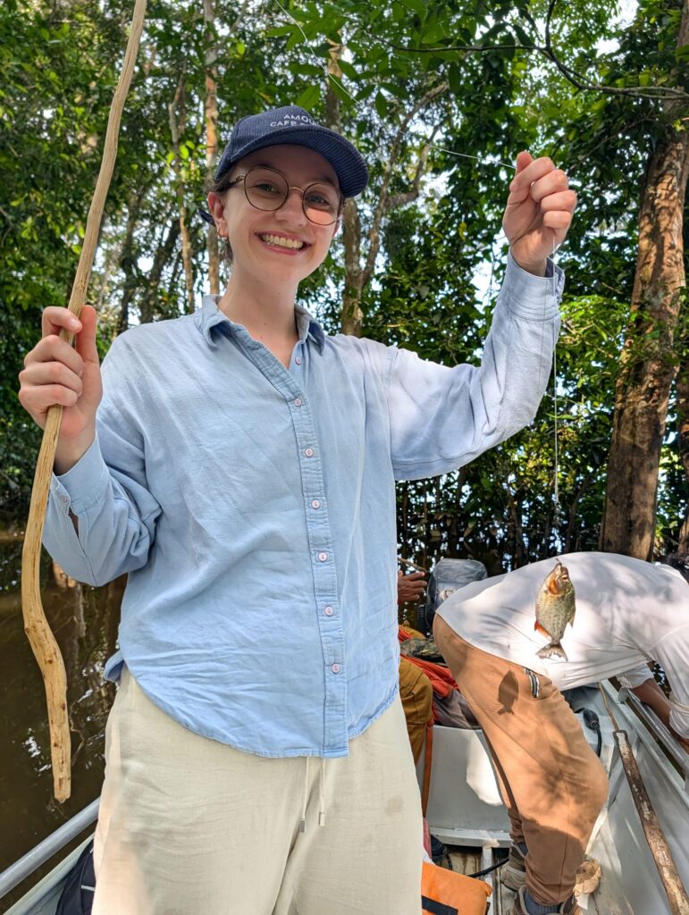Mujer pescando una piraña con caña de madera en el lago Tarapoto, Amazonas colombiano. 
