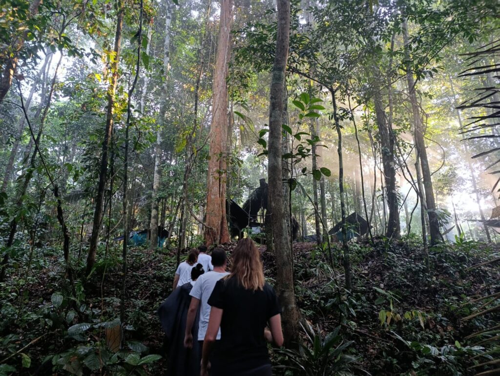 Viajeros caminando por senderos de montaña en la selva amazónica colombiana. Caminata ecológica y conexión con la naturaleza en el tour Amazonas Inmersión Total. 

